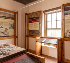 Interpretive panels in both English and Spanish surround a window